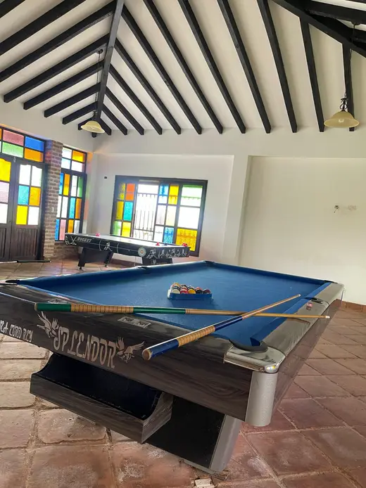 Mesa de billar azul en el salón con vitrales de colores