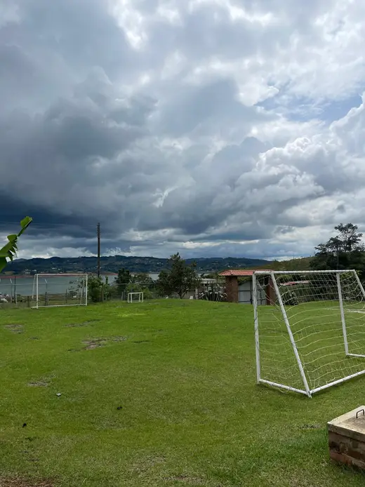 Cancha de fútbol de pasto con el lago al fondo
