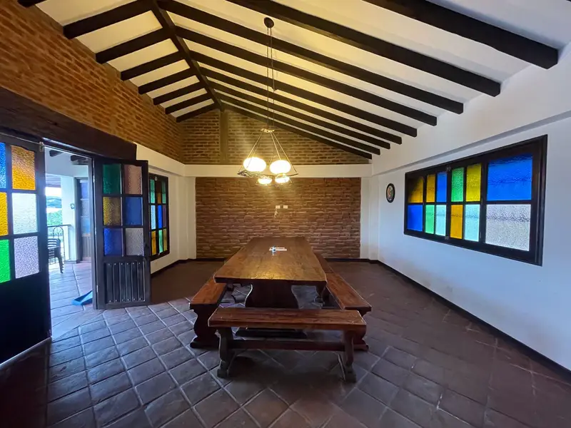 Comedor con mesa larga de madera y ventanas de vitrales