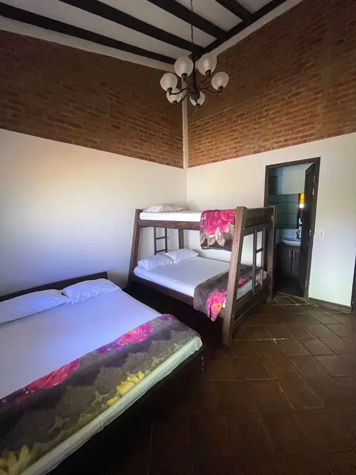 Habitación con cama doble, litera y vitrales de colores