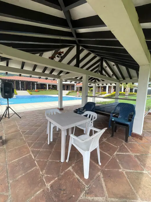 Kiosco con mesas y equipo de sonido, junto a la piscina