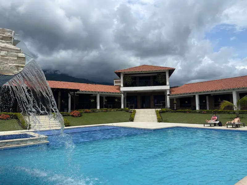 Piscina con cascada frente a la casa principal de la finca