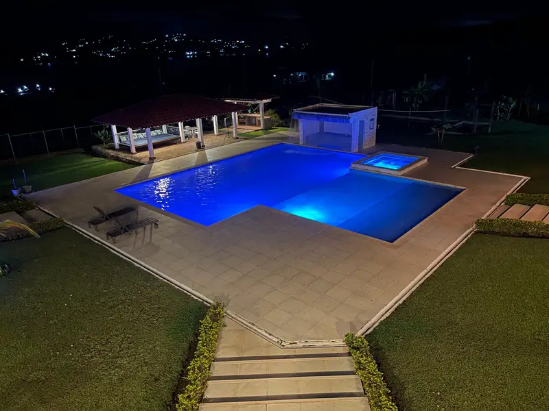 Vista de la piscina y la cascada iluminadas, desde arriba